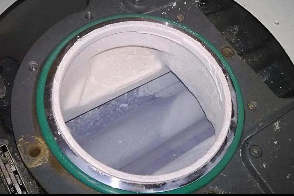 Condensation of white ammonium hexafluorosilicate crystals inside the circular opening of a Roots pump operated at too low a temperature